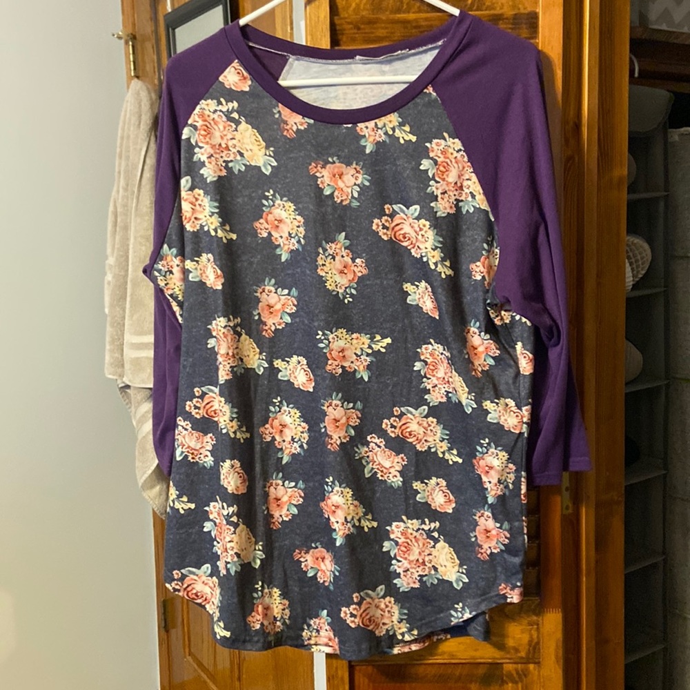 Grey top with purple sleeves. Flowers on main part of shirt (not the sleeves)